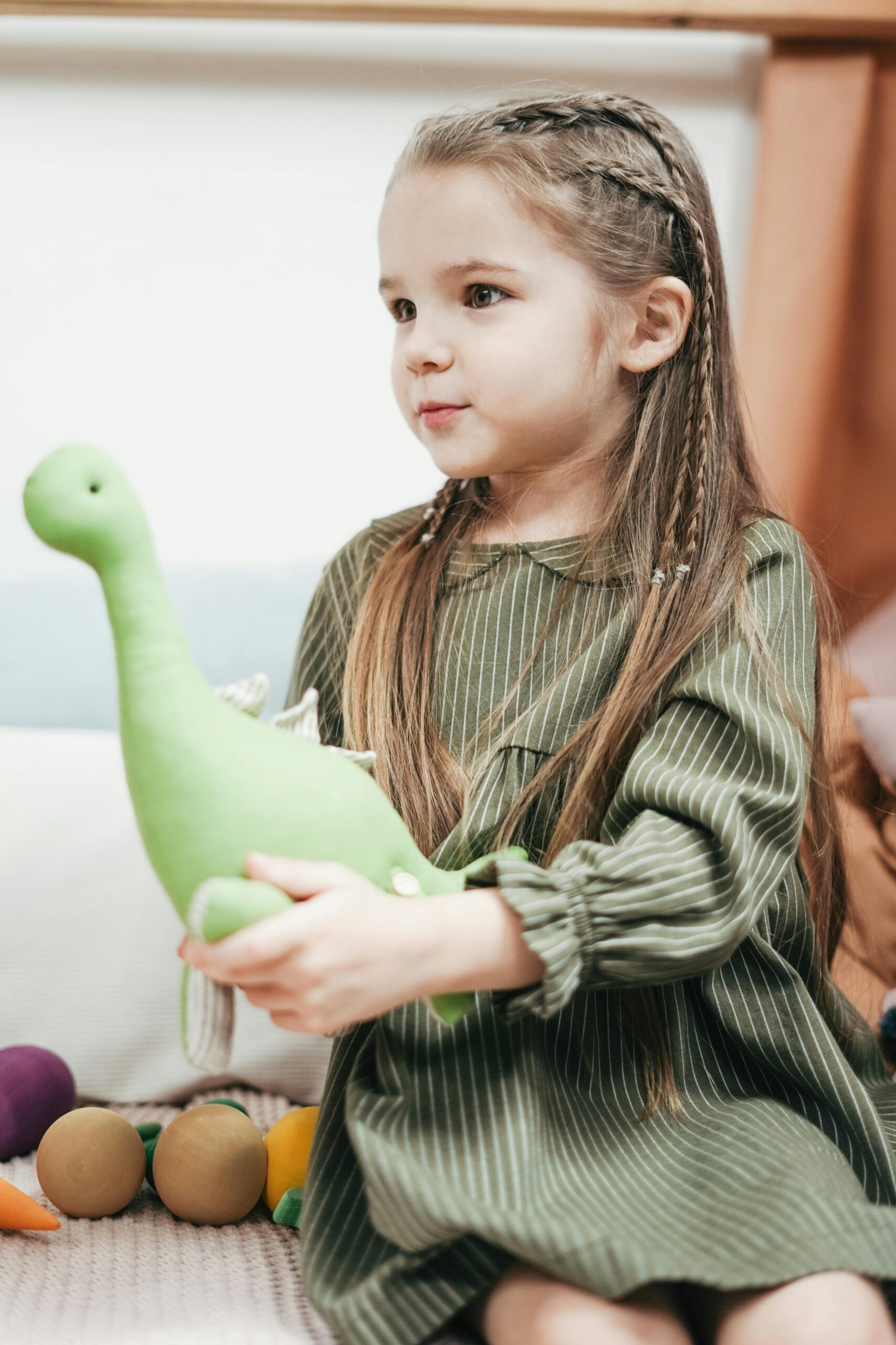Young girl holding toy dinosaur
